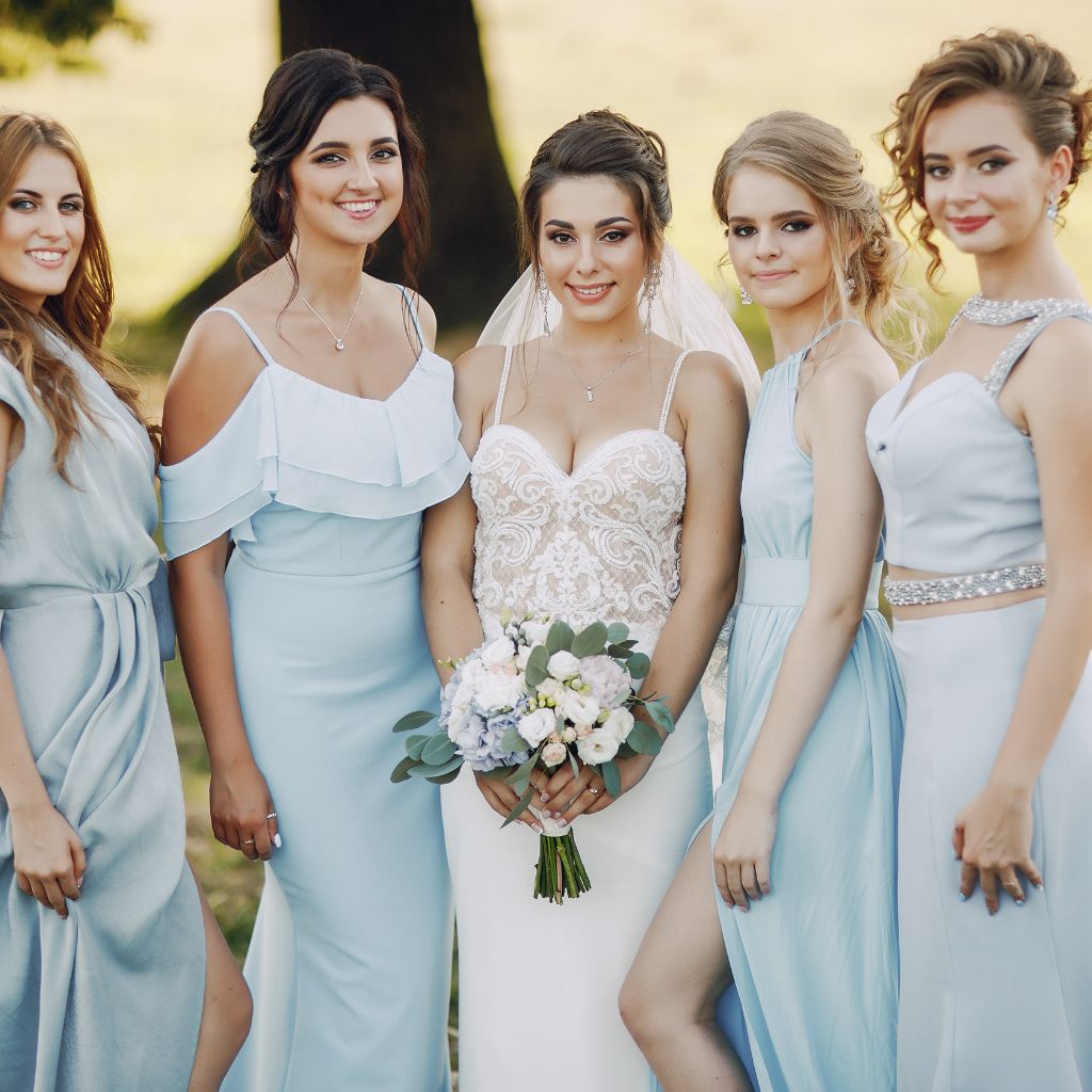damas de honor con vestido celeste junto al novia vestida de blanco