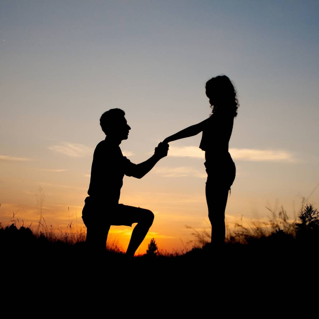 novio pidiendo matrimonio a su novia con el atardecer